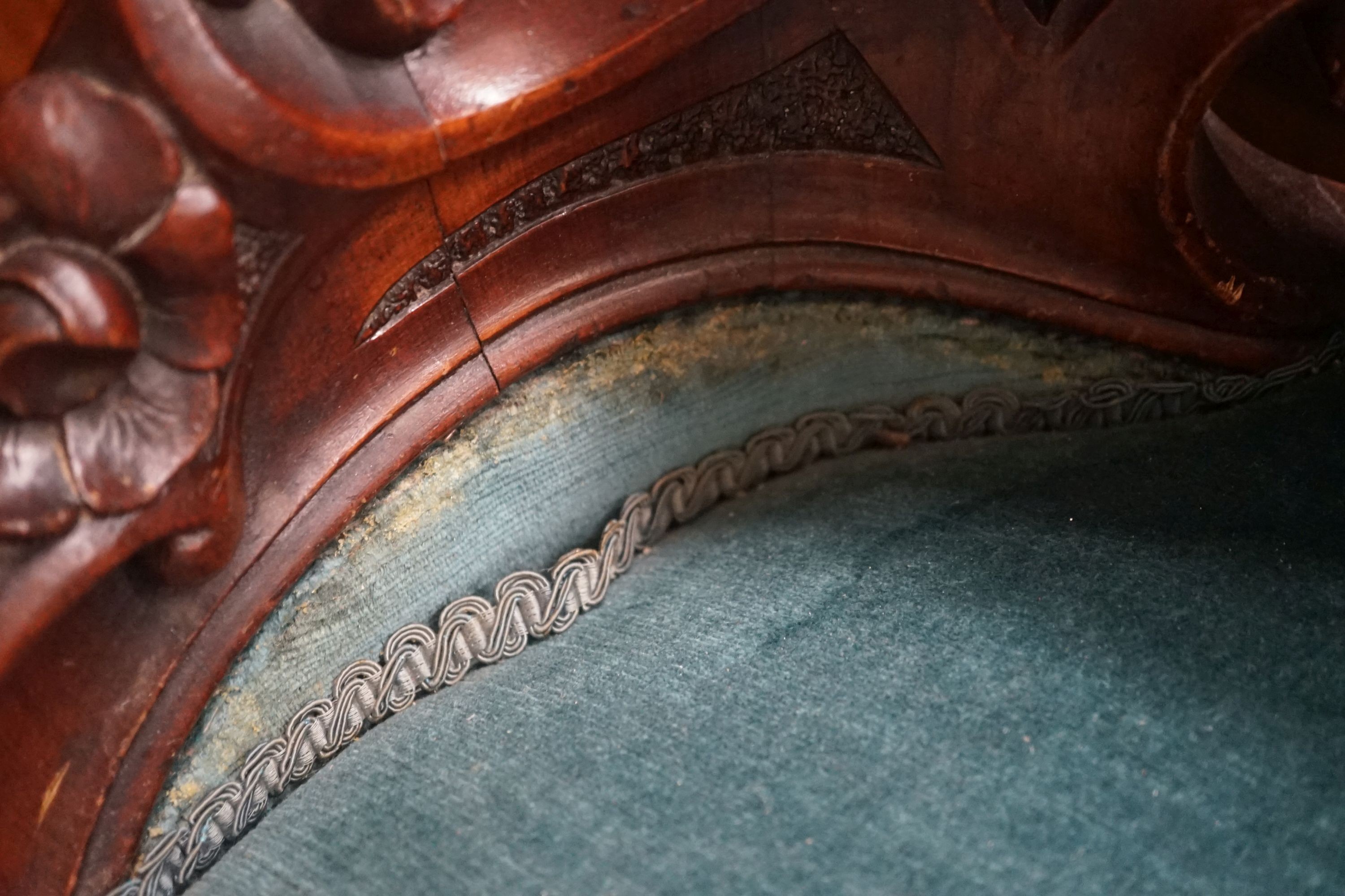 A Victorian carved mahogany spoon back salon chair with buttoned blue upholstery